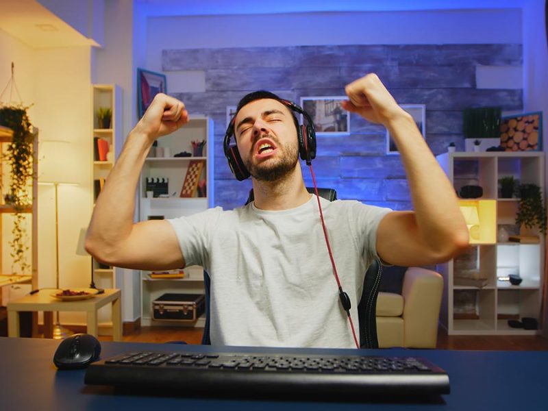 Young professional game player screaming with hands raised after his victory